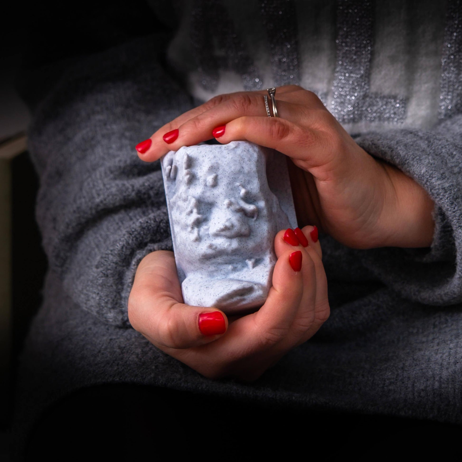 Mani di donna con smalto rosso che tiene una scultura di Vedo in 3D creata dall'ecografia del bambino