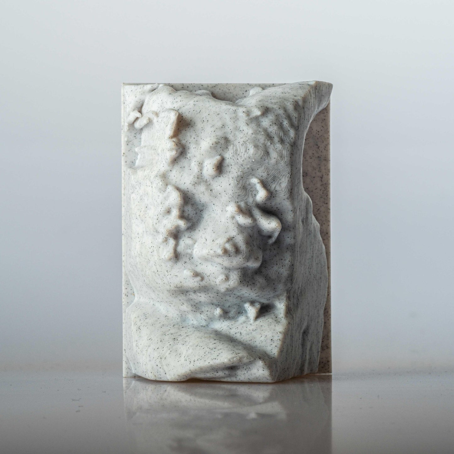 Scultura di Vedo in 3d creata dall'ecografia appoggiata su un piano bianco con sfondo posteriore bianco