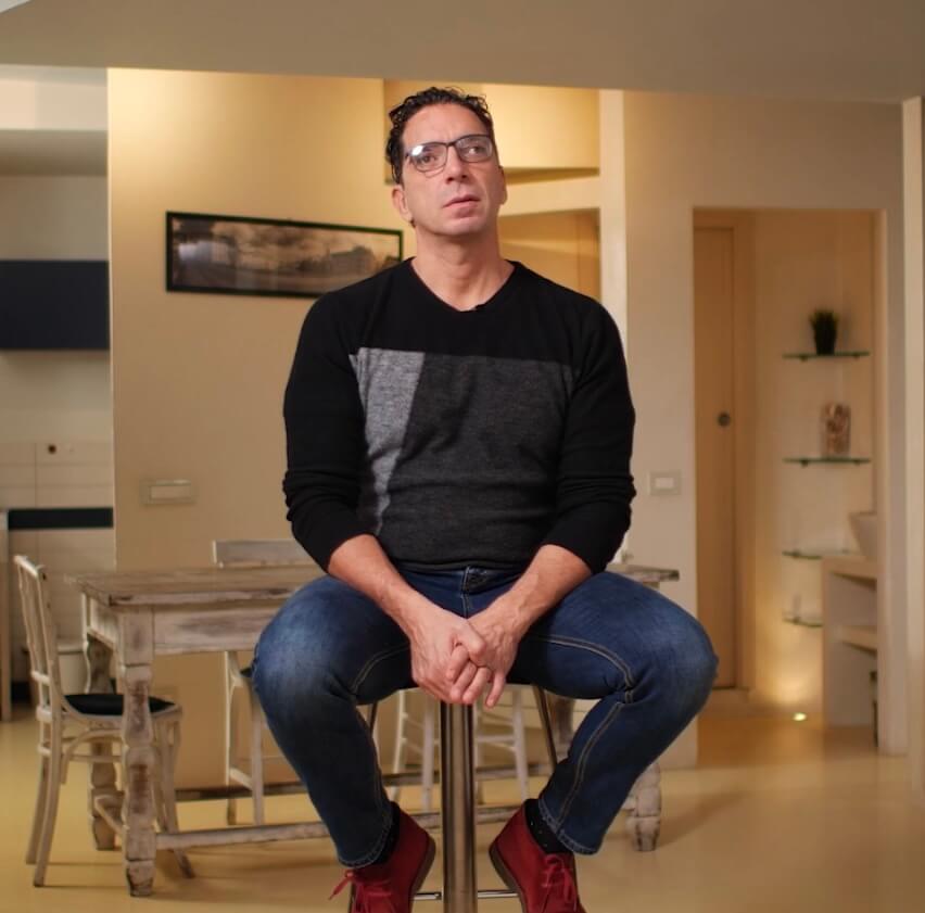 Cristian Brunetti ideatore di Vedo in 3d, seduto su uno sgabello in casa che presenta la sua idea